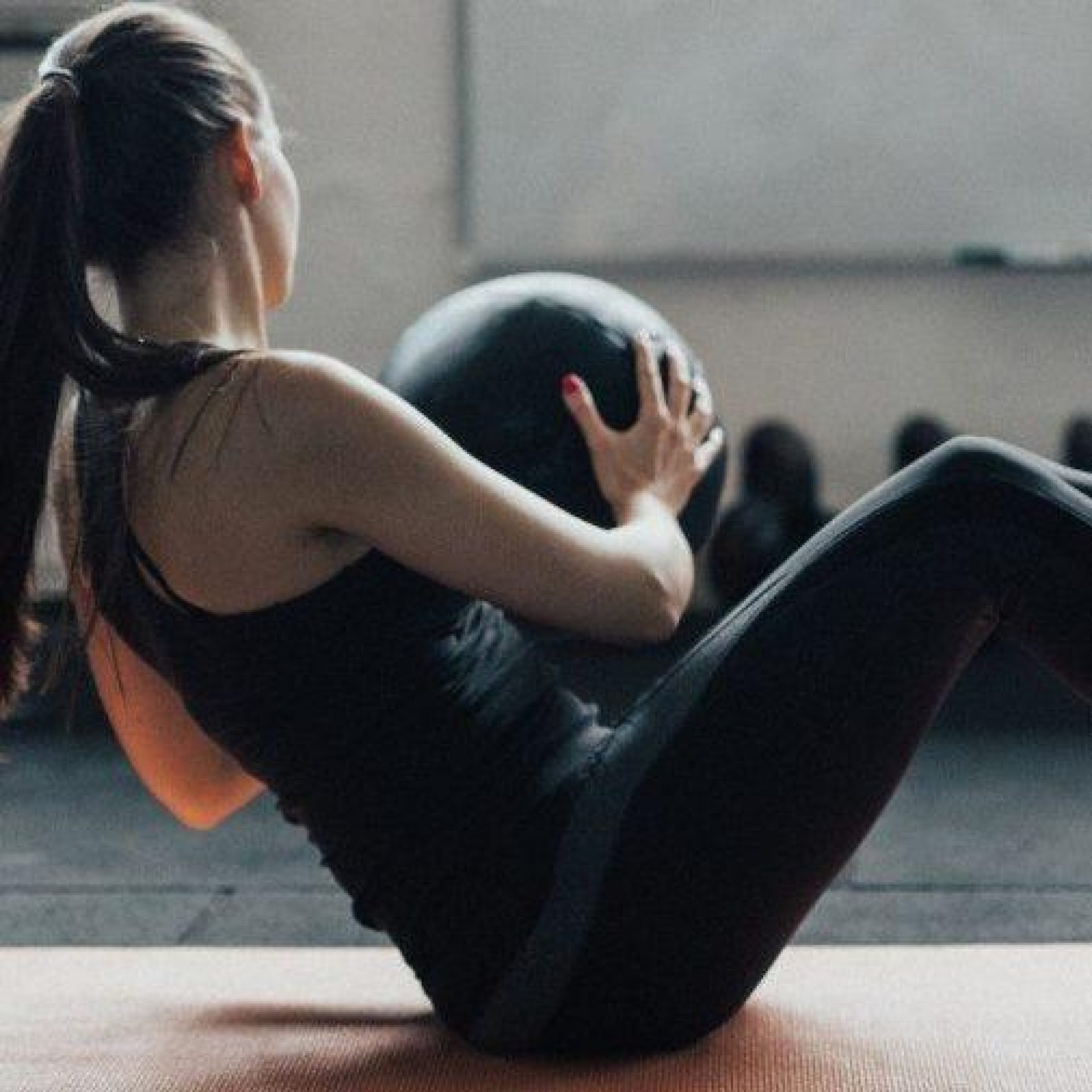 Fit Young Woman With Ponytail Uses Medicine Ball To Train Her Picture Id692888422